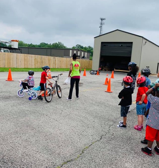 Adult and children with bicycles and helmets outdoors