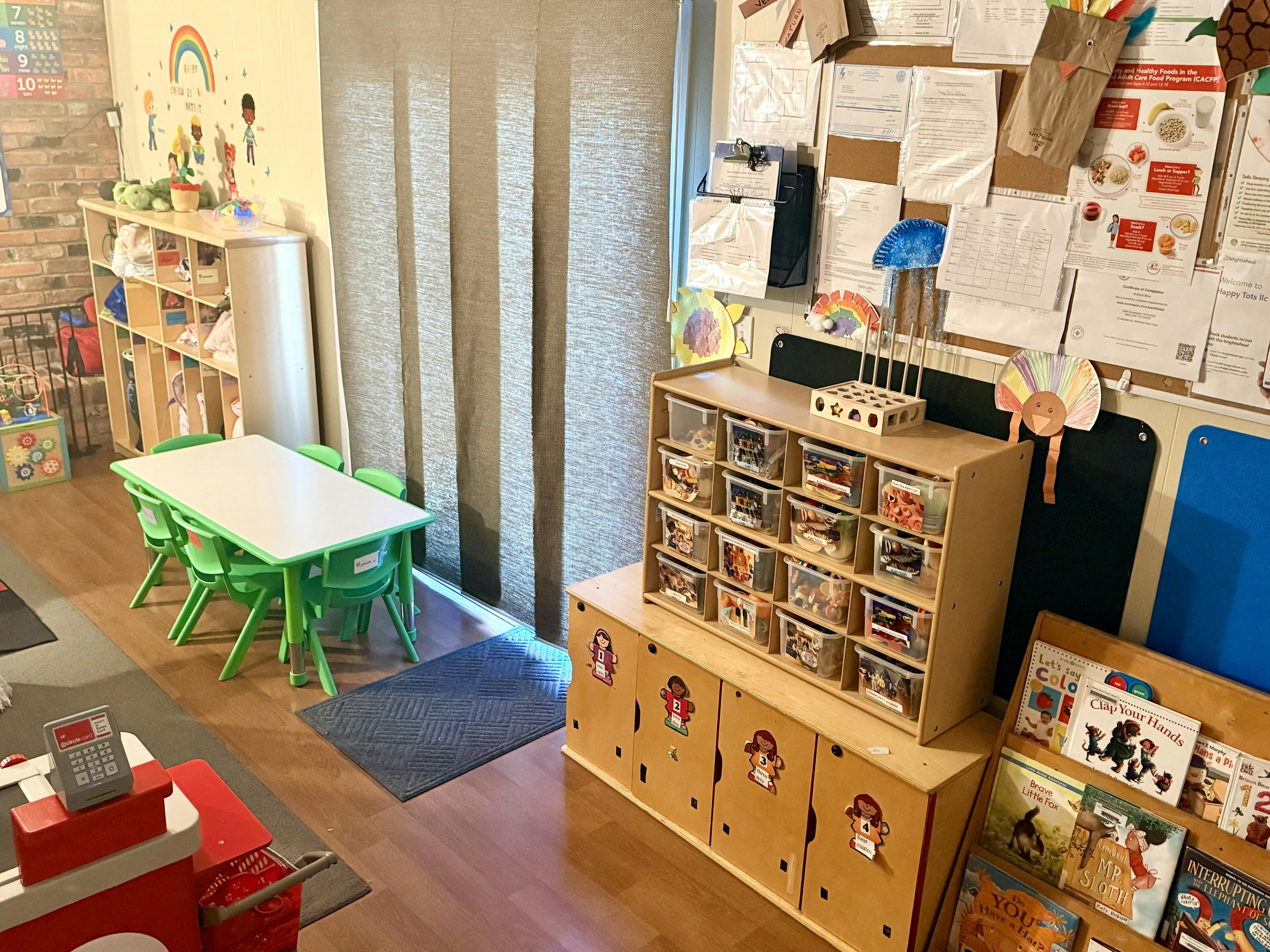Classroom with child-sized table and chairs, storage units, and bulletin board