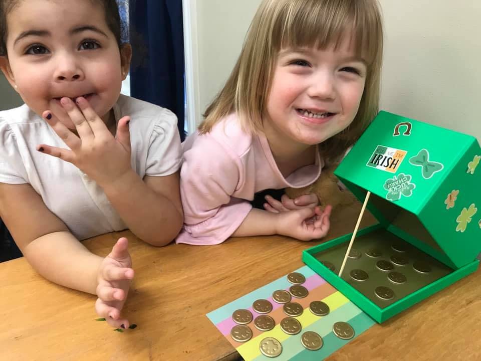 Two children with a green box and coins