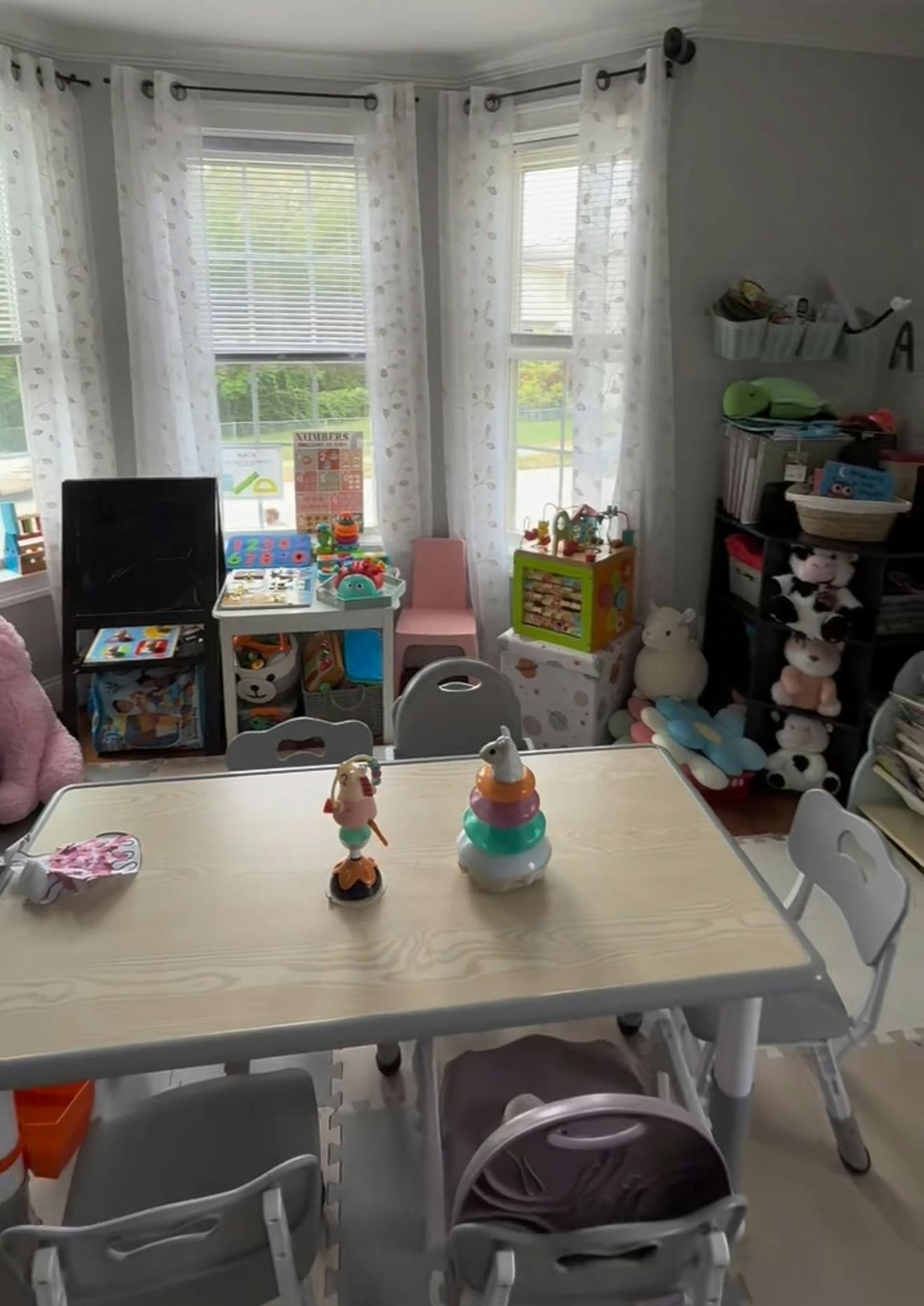 Playroom with a table and chairs, toys, and windows