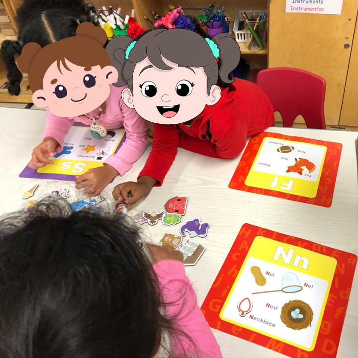 Children playing with letter cards and animal cutouts on a table