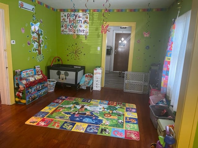 Playroom with a colorful rug, toys, and green walls