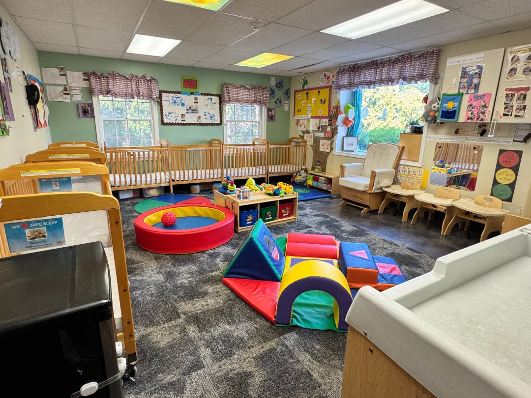 Baby room with multiple cribs, a changing table, and soft play equipment