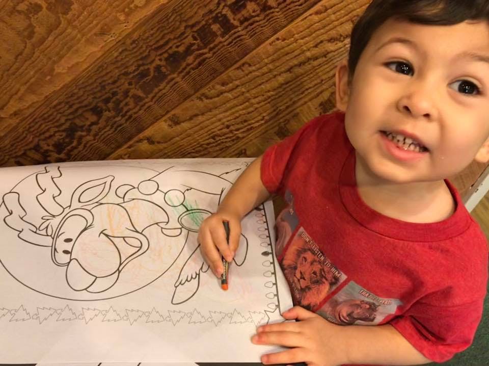 Child coloring a picture of a cartoon animal