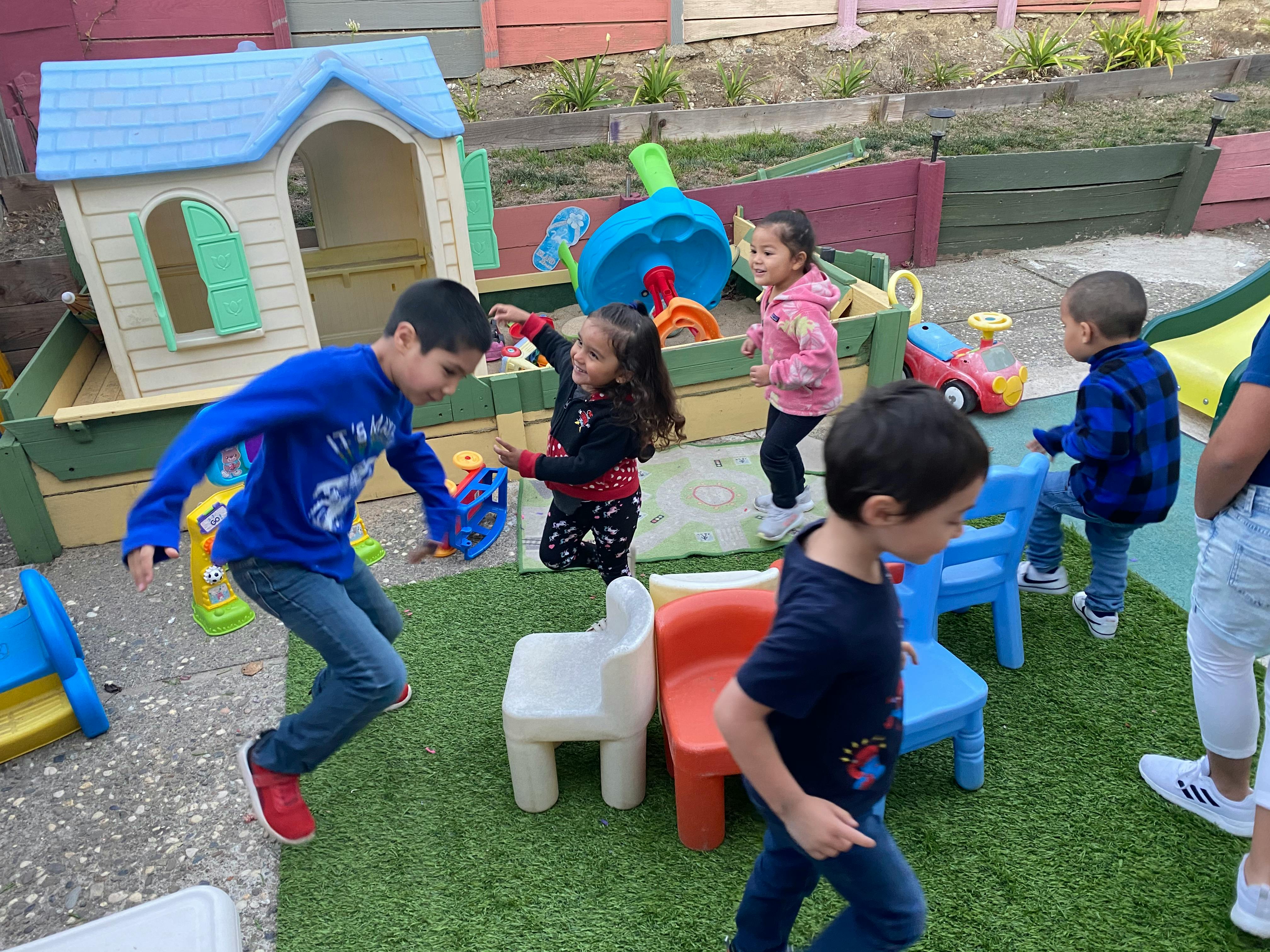 Children playing outdoors with toys and playhouses