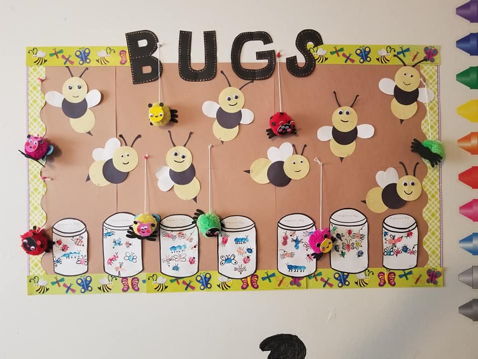 Bulletin board with the word "BUGS" and cutouts of bees, ladybugs, and jars