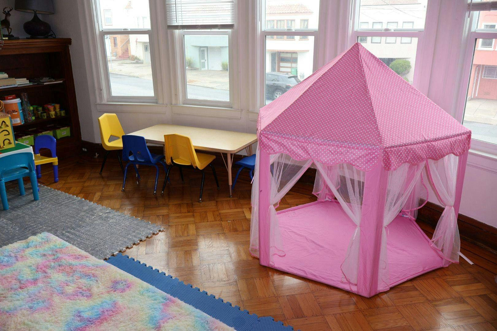 Pink play tent in a room with a table and chairs