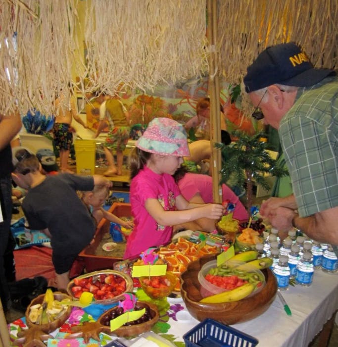 Child and person at a table with bowls of fruit
