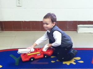 Child playing with a toy fire truck