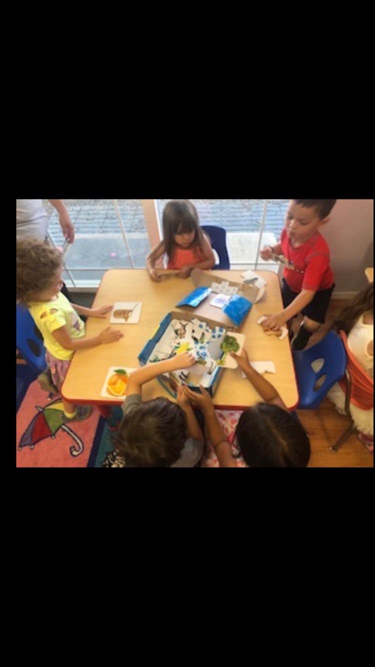 Children gathered around a table playing with toys