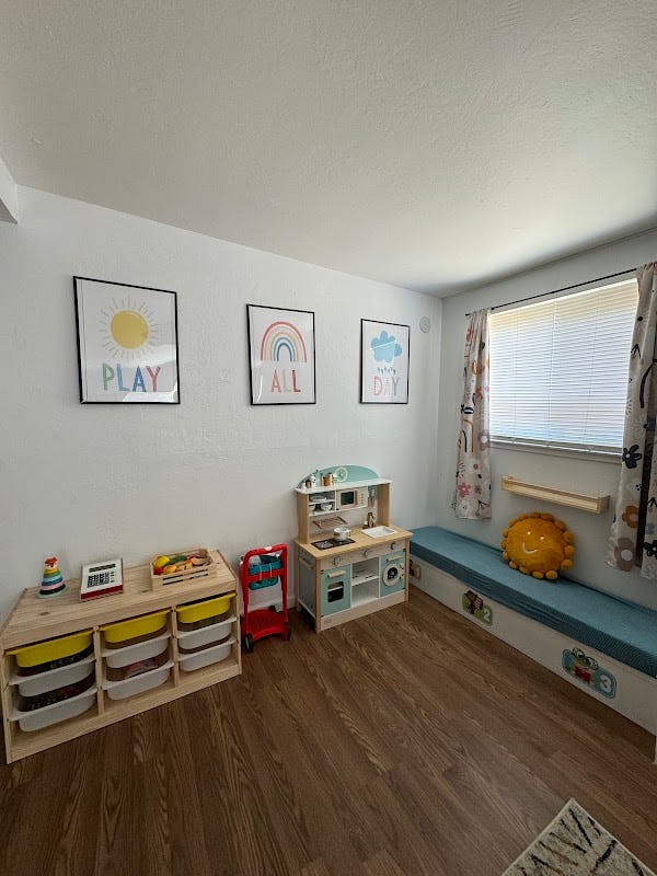 Playroom with a toy kitchen, storage unit, and wall decor