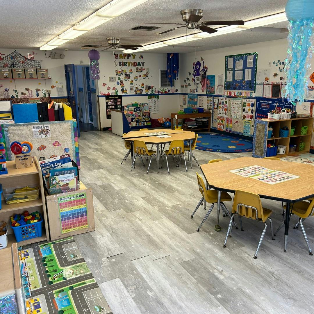 Classroom with small tables and chairs, shelves, and decorations on walls