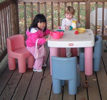 Two children playing with toys at a small table