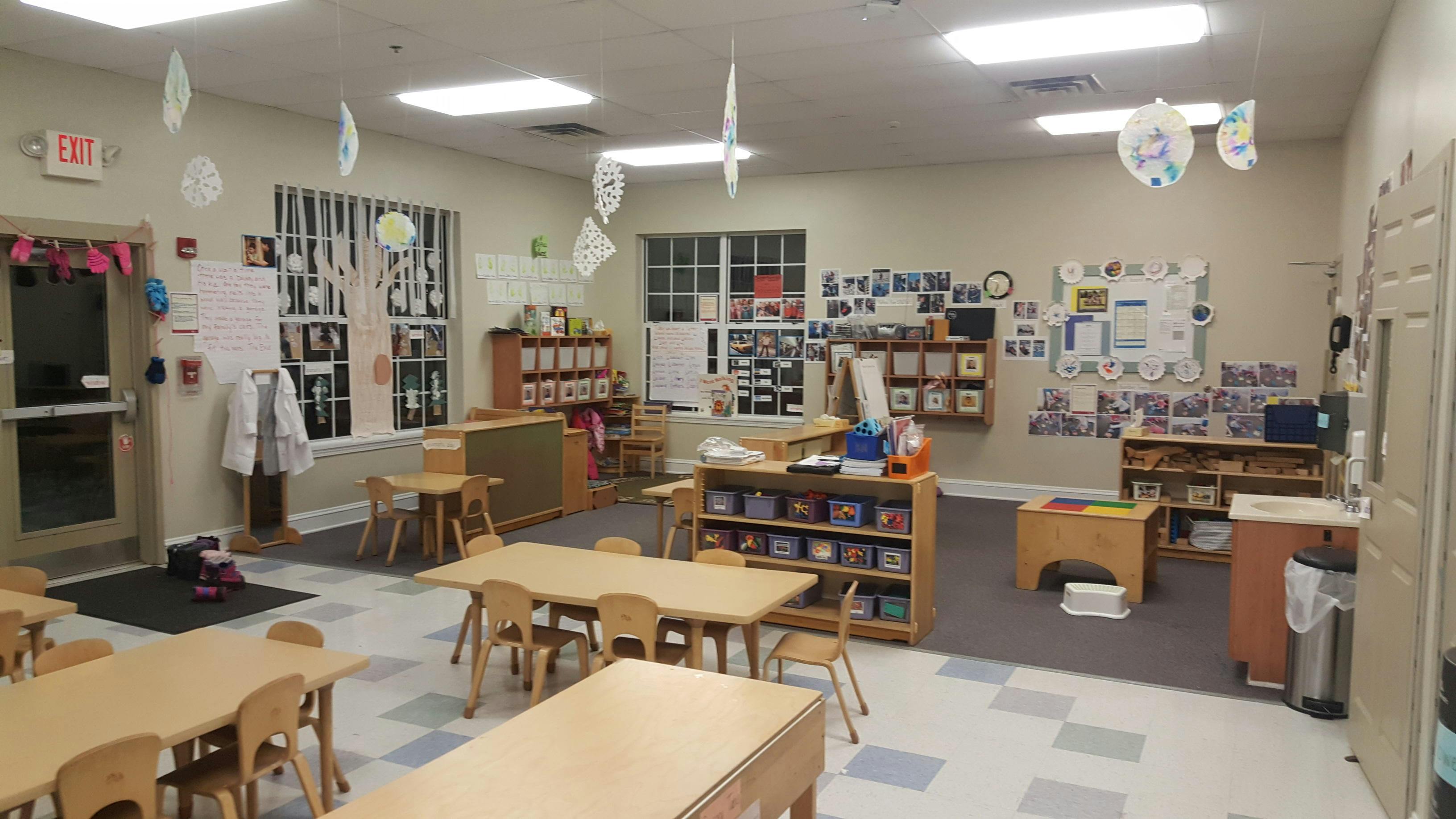Classroom with child-sized tables and chairs, shelves, and decorations