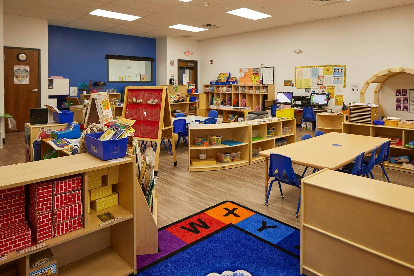 Classroom with tables, chairs, and shelves