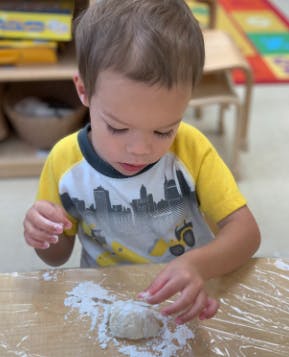 Child playing with dough and flour