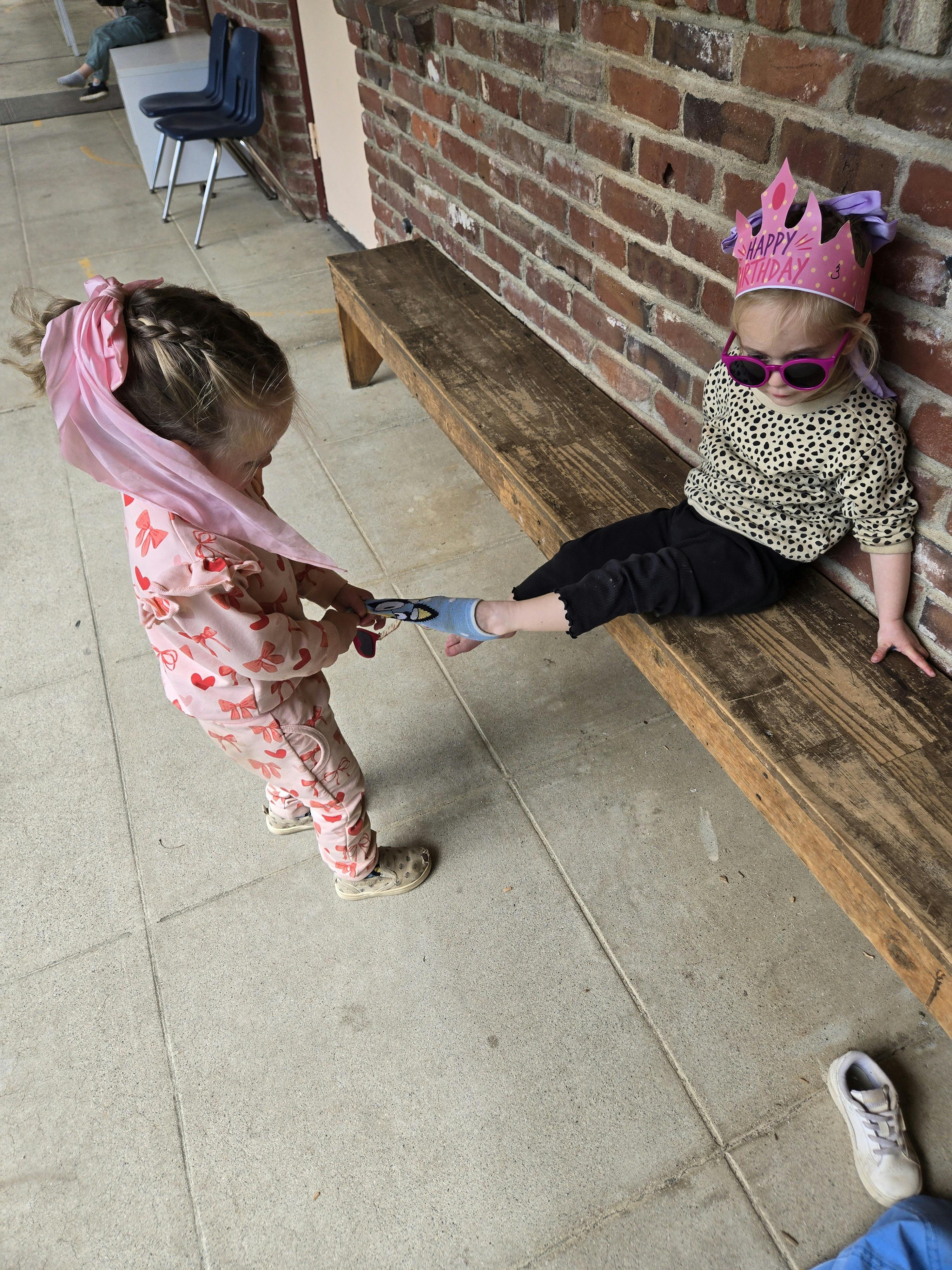Child pulling on another child's foot