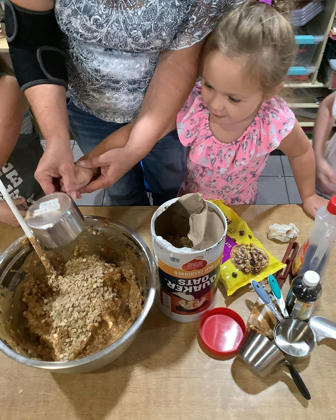 Person and child mixing ingredients in a bowl