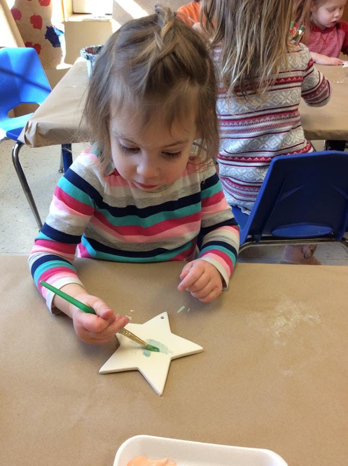 Child painting a star-shaped craft