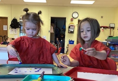 Two children painting in a classroom