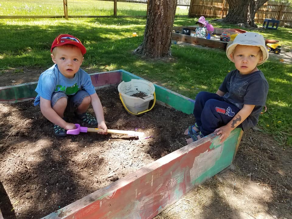 Two children playing in a sandbox