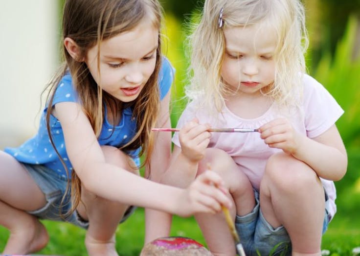 Two children painting outdoors