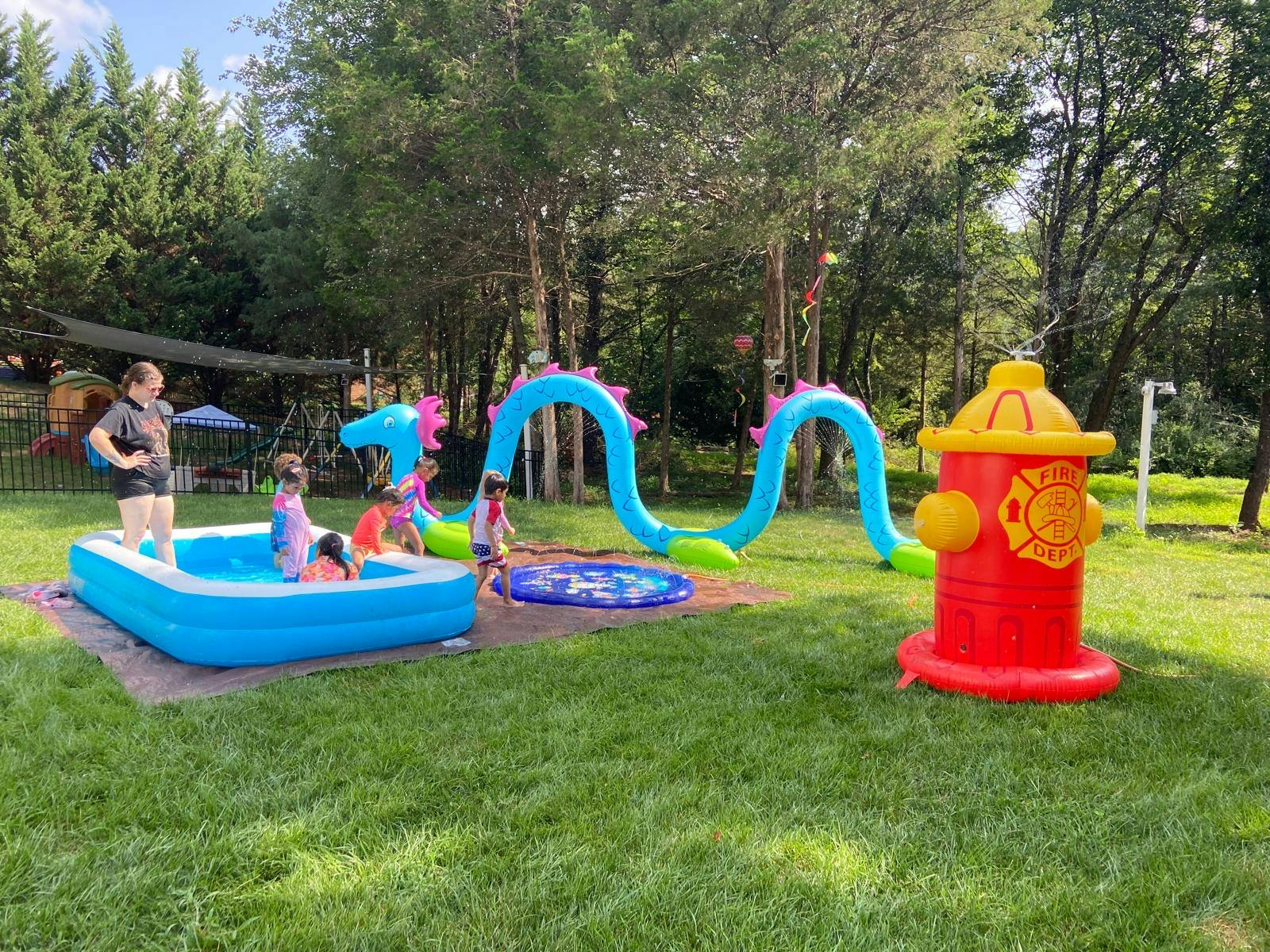 People playing with inflatable pool toys in a grassy backyard