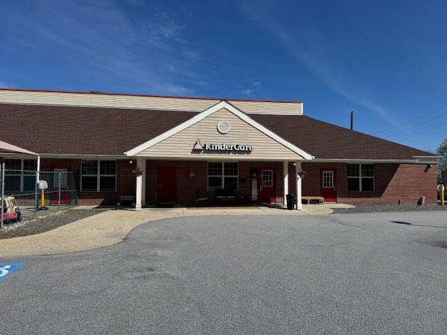 Brick building with a sign that reads "KinderCare" over the main entrance