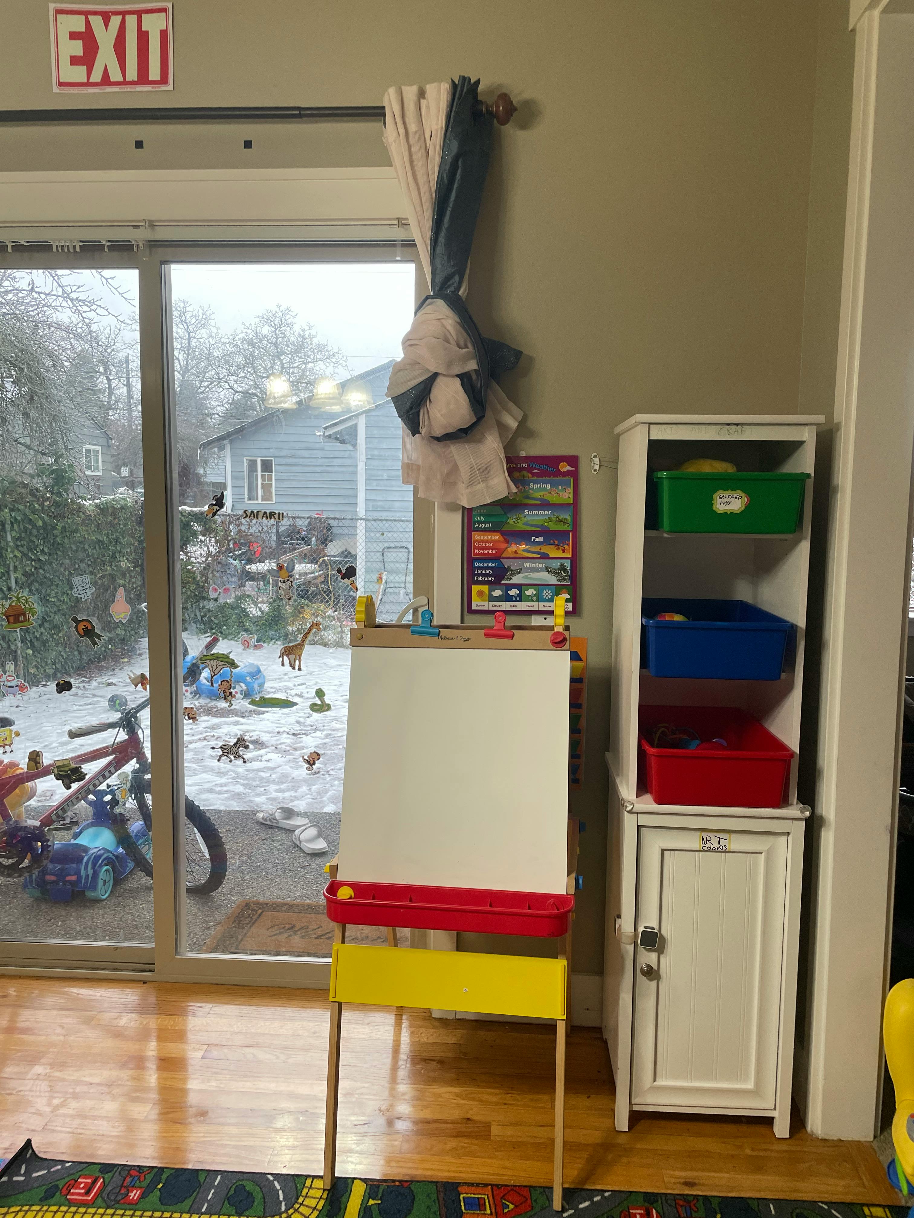 Easel with a white board and a cabinet with colorful bins