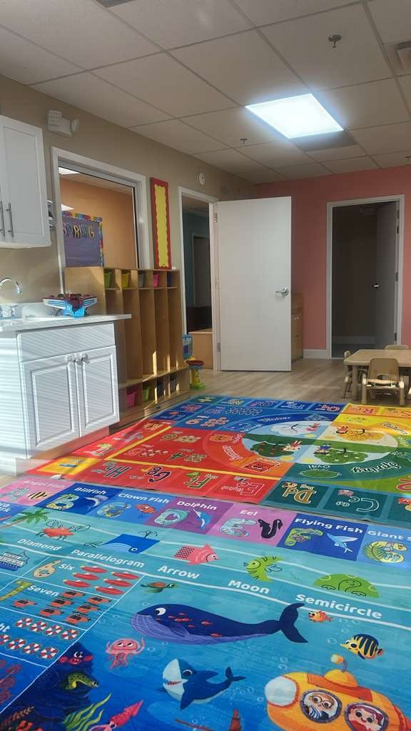 Colorful educational rug with shapes and sea life in a child care classroom