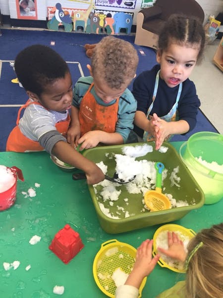 Children playing with snow in a classroom