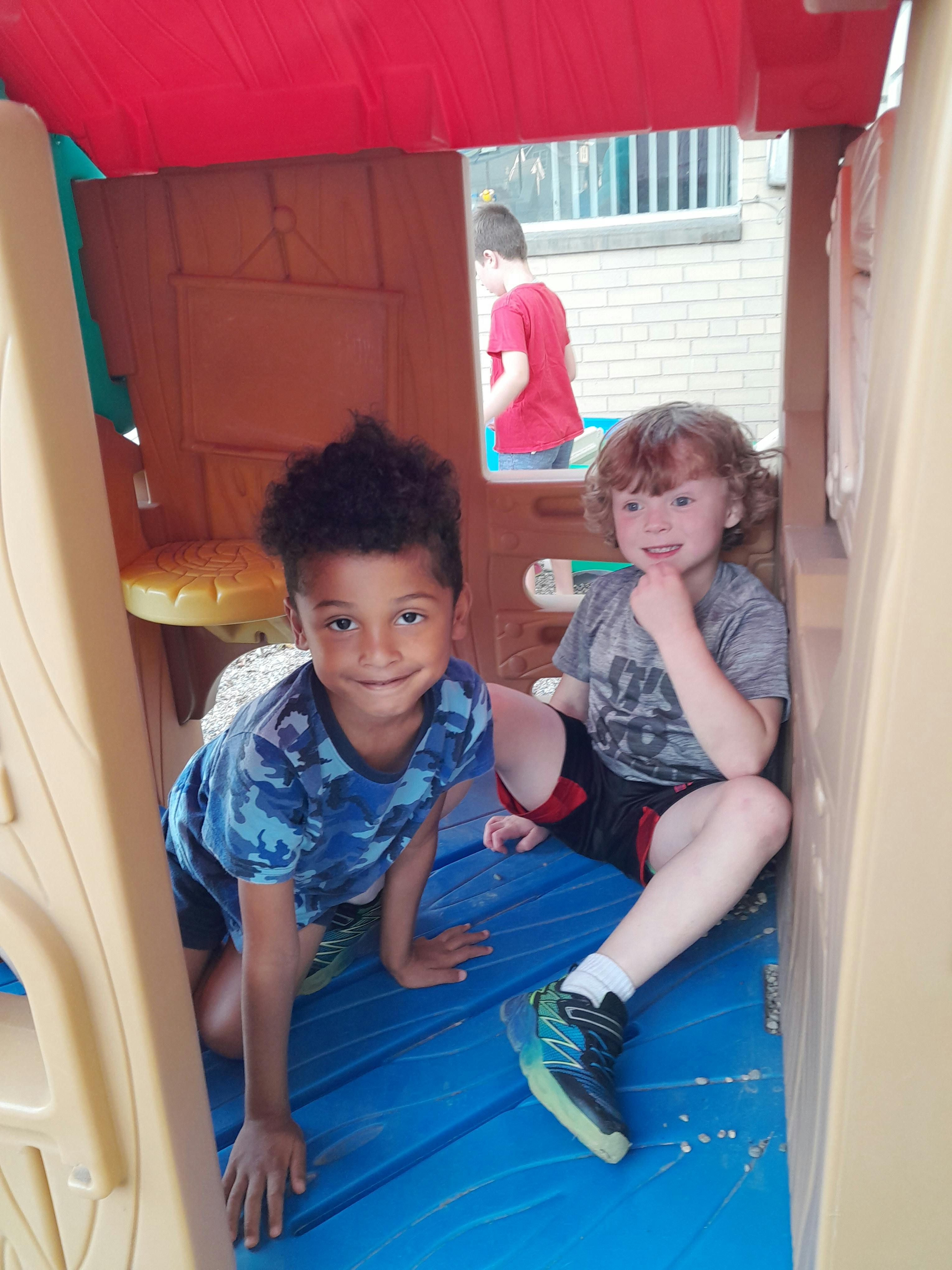 Two children inside a playhouse