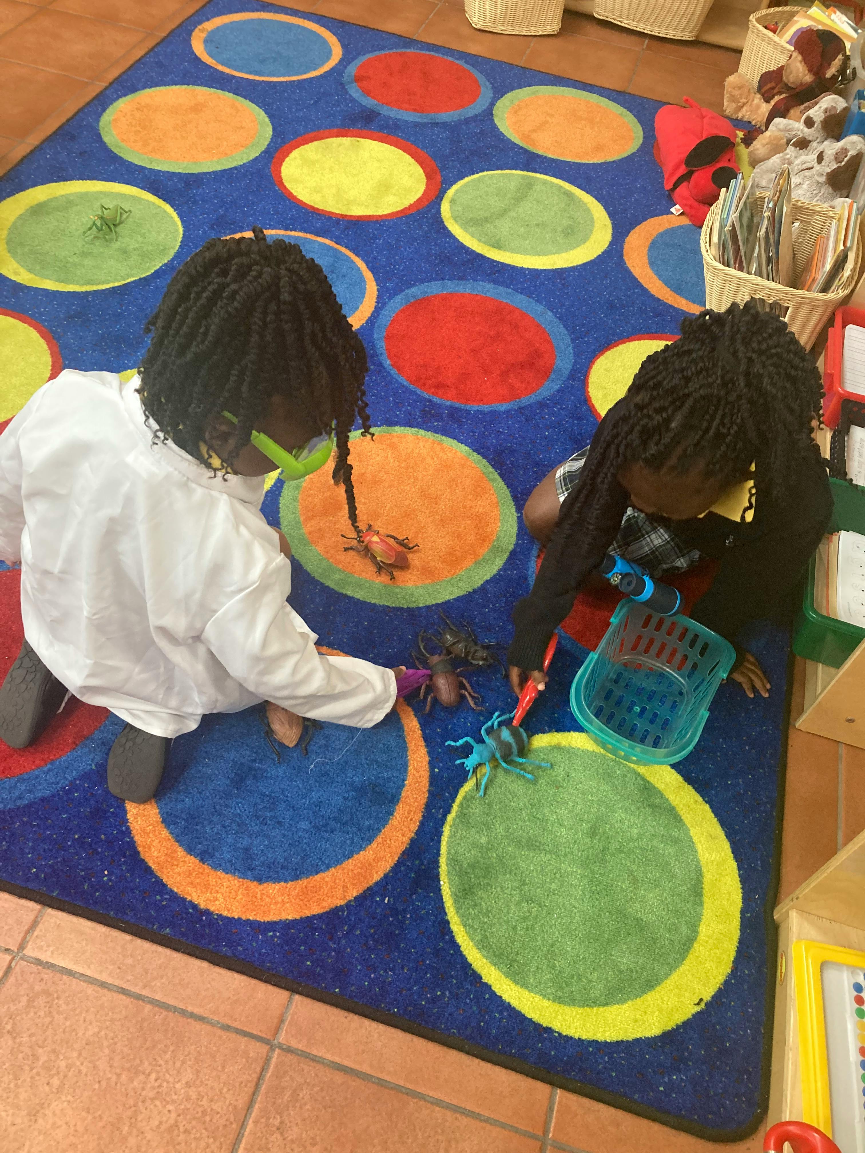 Two children playing with toys on a colorful rug
