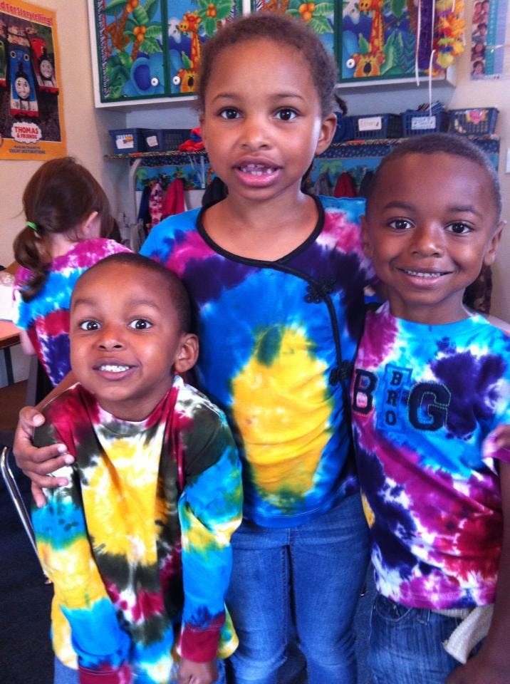 Three children wearing tie-dye shirts