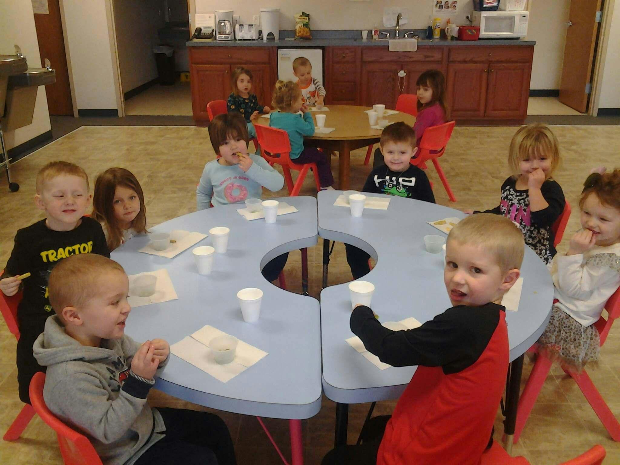 Children sitting at tables in a classroom