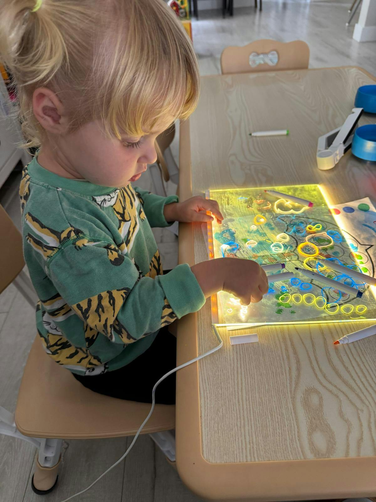 Child coloring on a light-up tracing pad