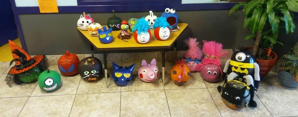 Decorated pumpkins and gourds on a table and floor
