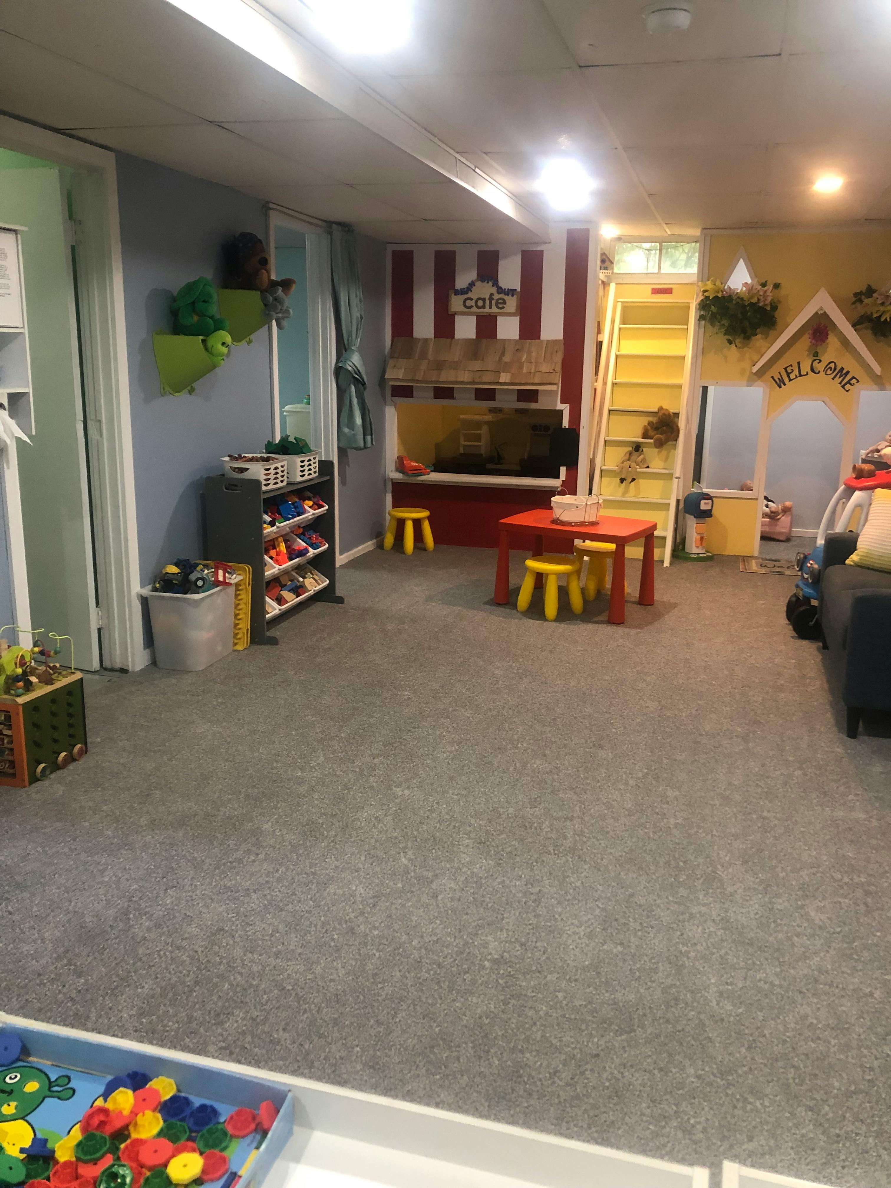 children's playroom with a cafe, shelves, and toys