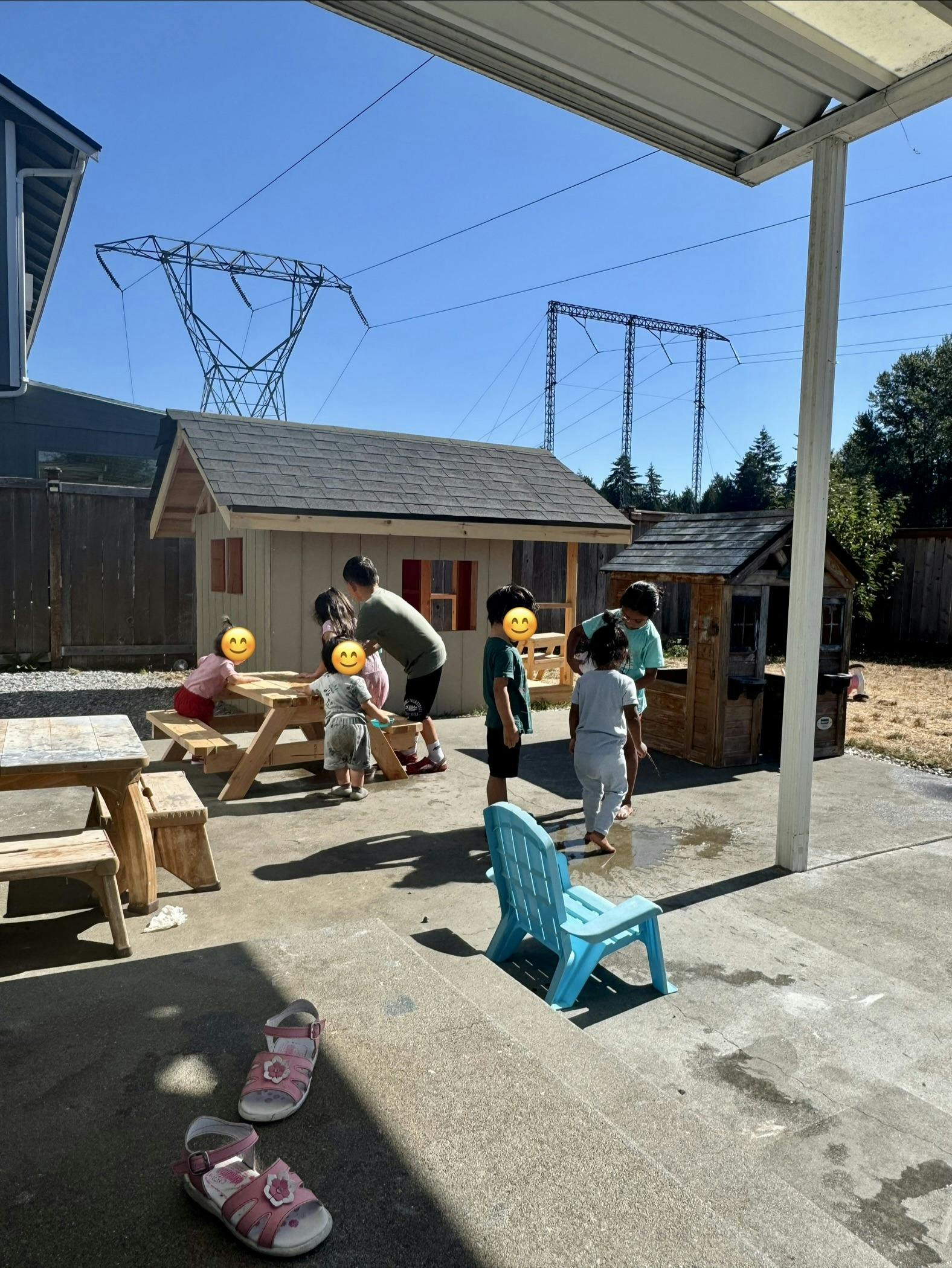 Group of children playing together near a playhouse in a backyard