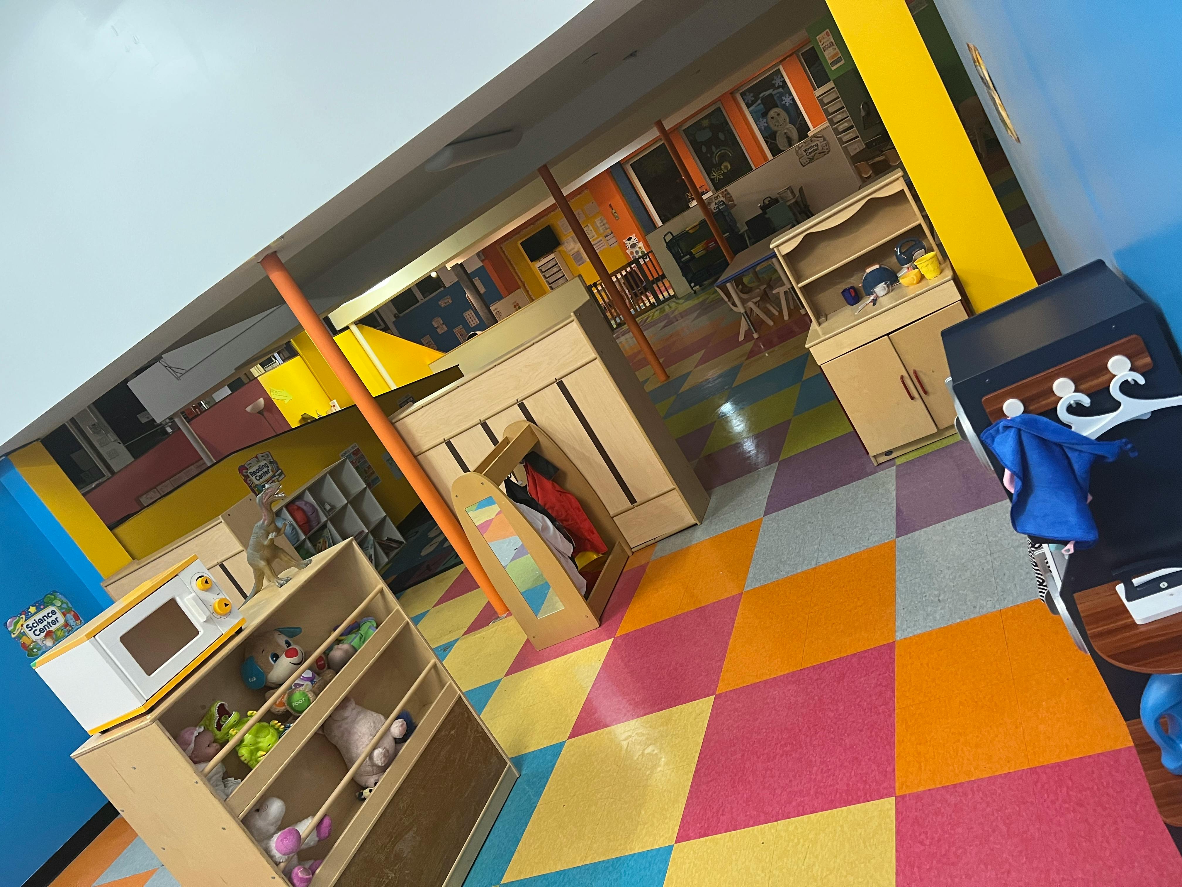 Playroom with colorful checkered floor and various wooden play furniture