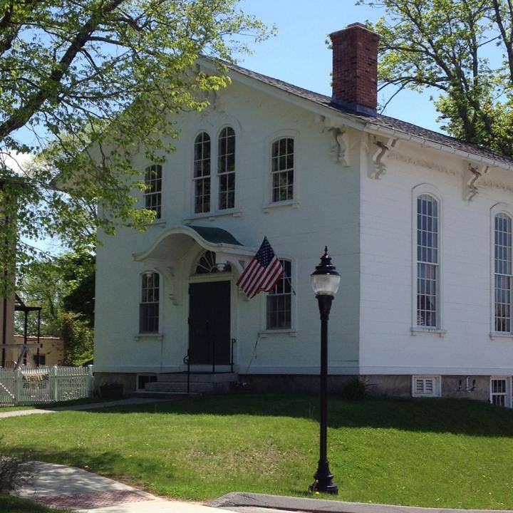 White building with an American flag hanging by the entrance
