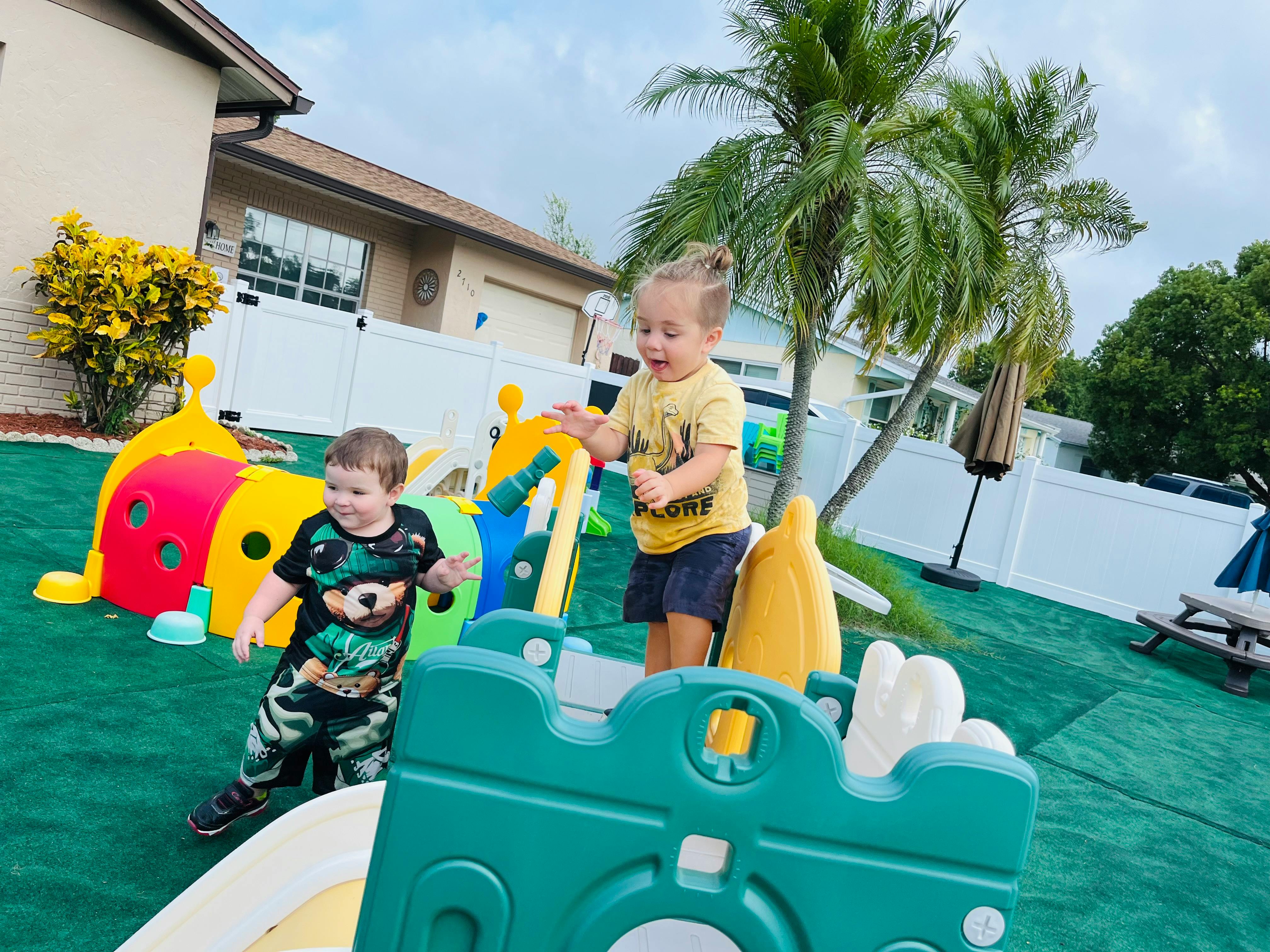 Two children playing on colorful playground equipment