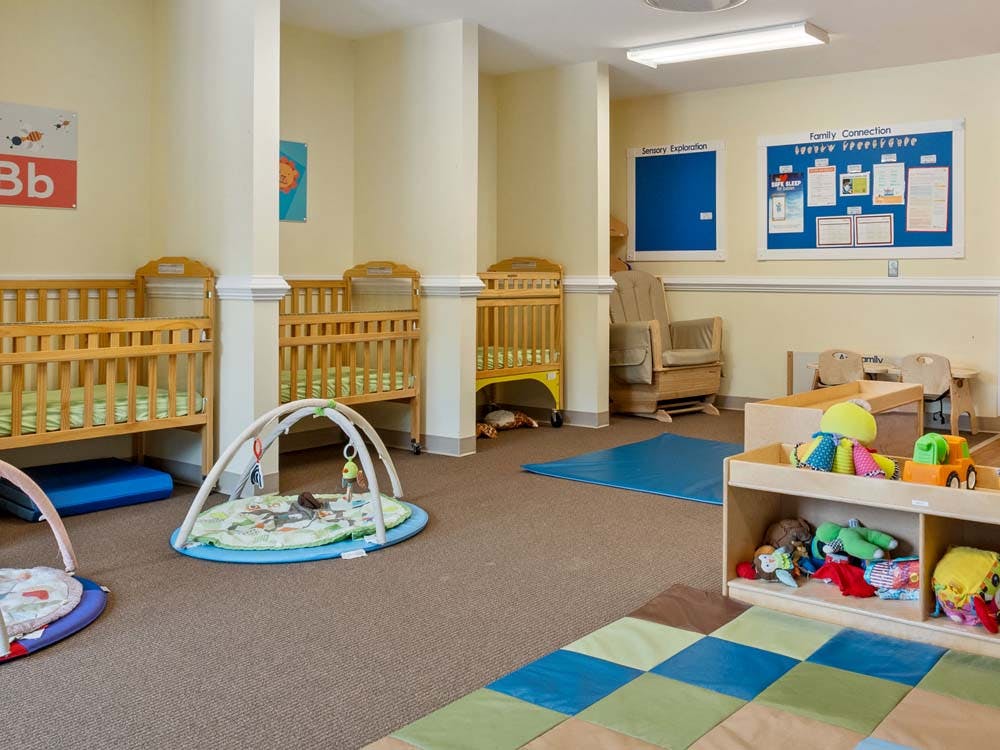 Cribs, play mats, and toys in a nursery room