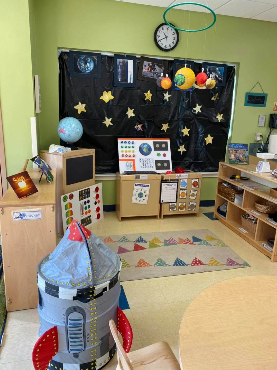 Classroom with space-themed decorations and a rocket play structure