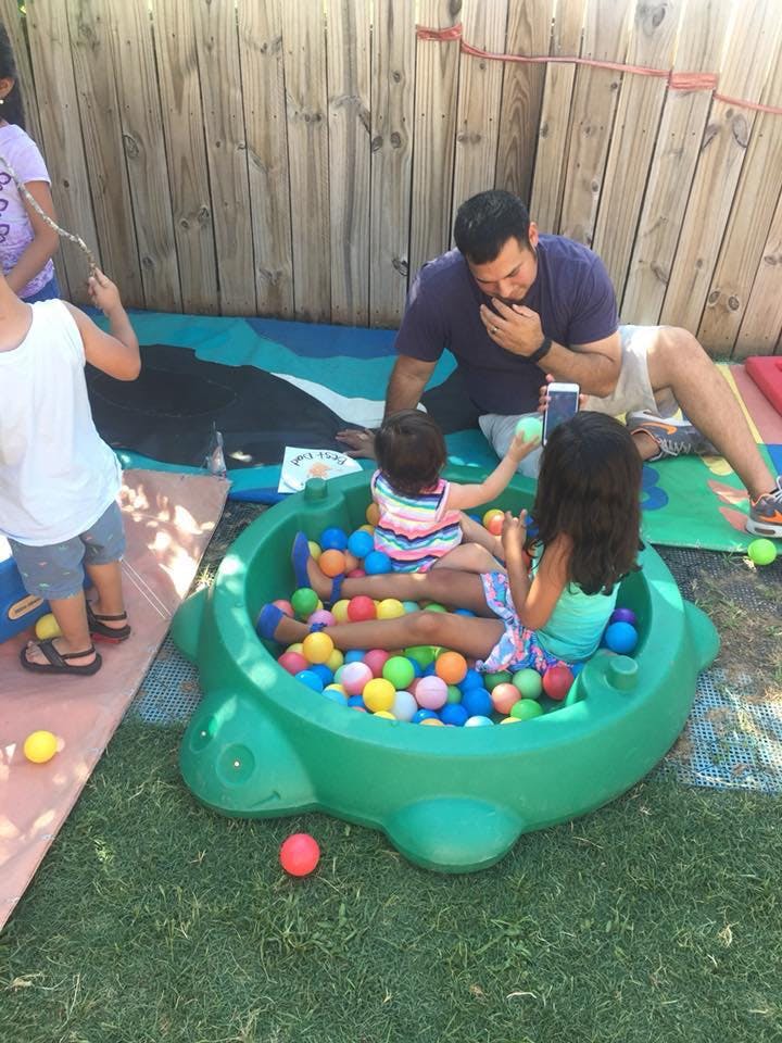Person watching children play in a ball pit