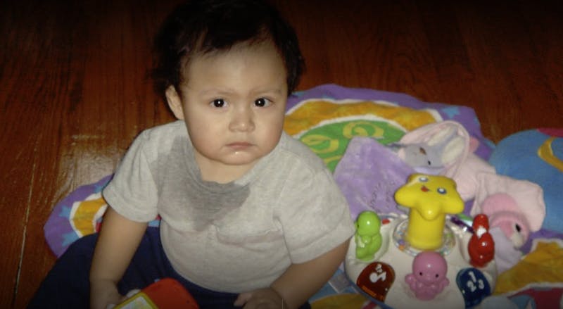 Child sitting on floor with a toy