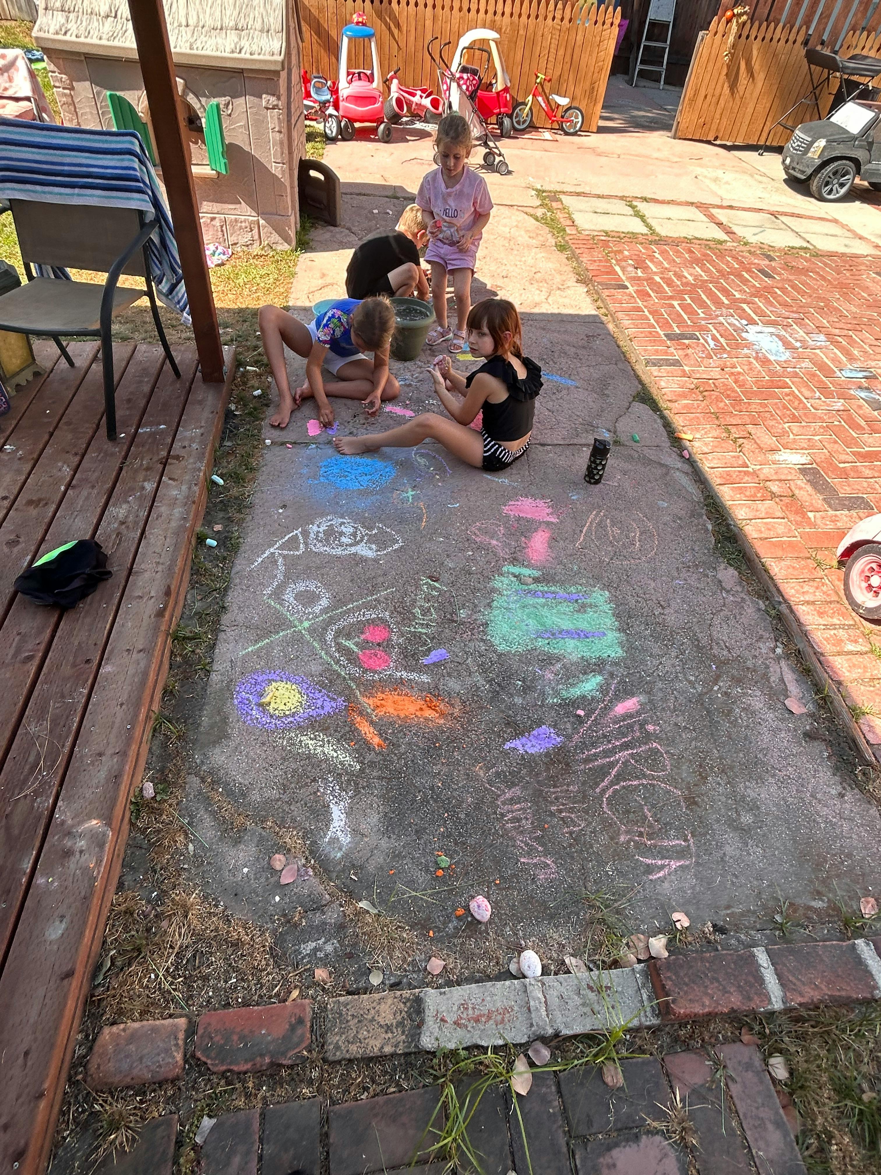 Children drawing with chalk on a paved surface