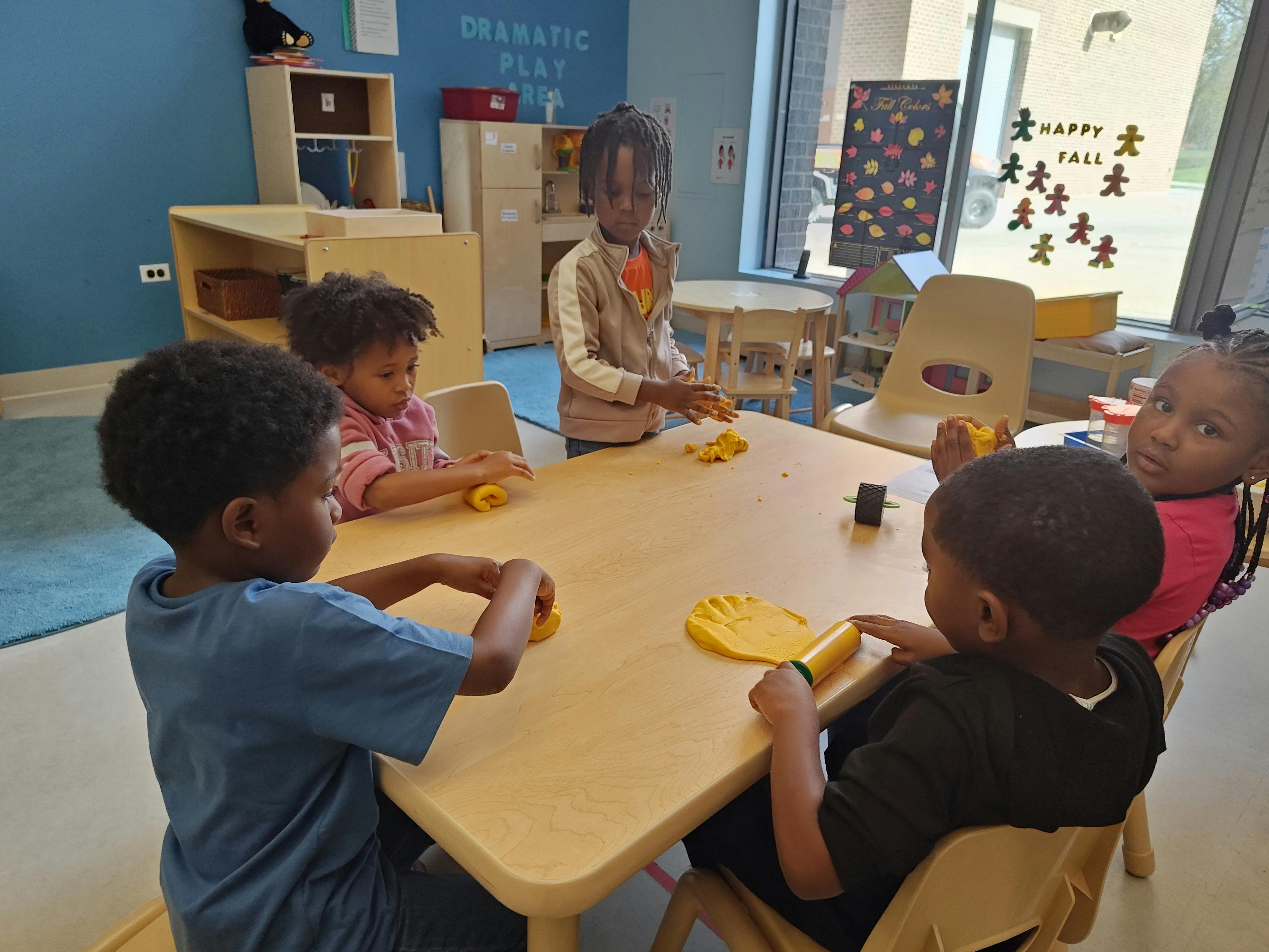 Children playing with toys at a table in a classroom