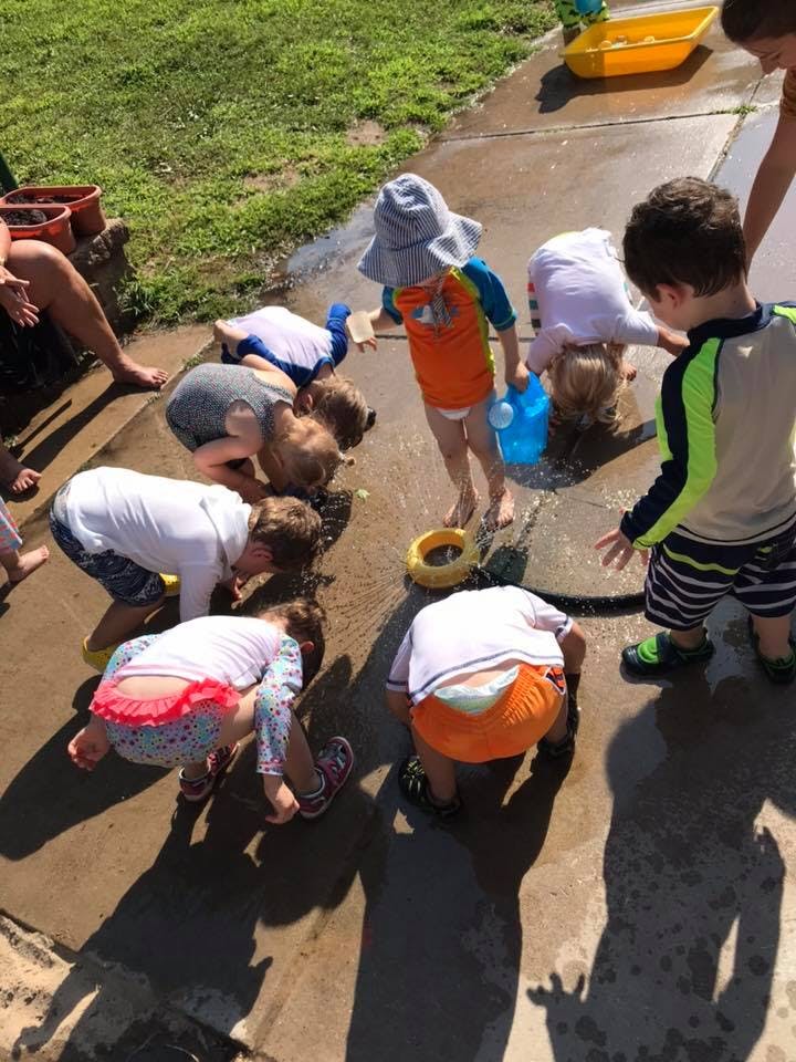 Children playing with water on a paved surface