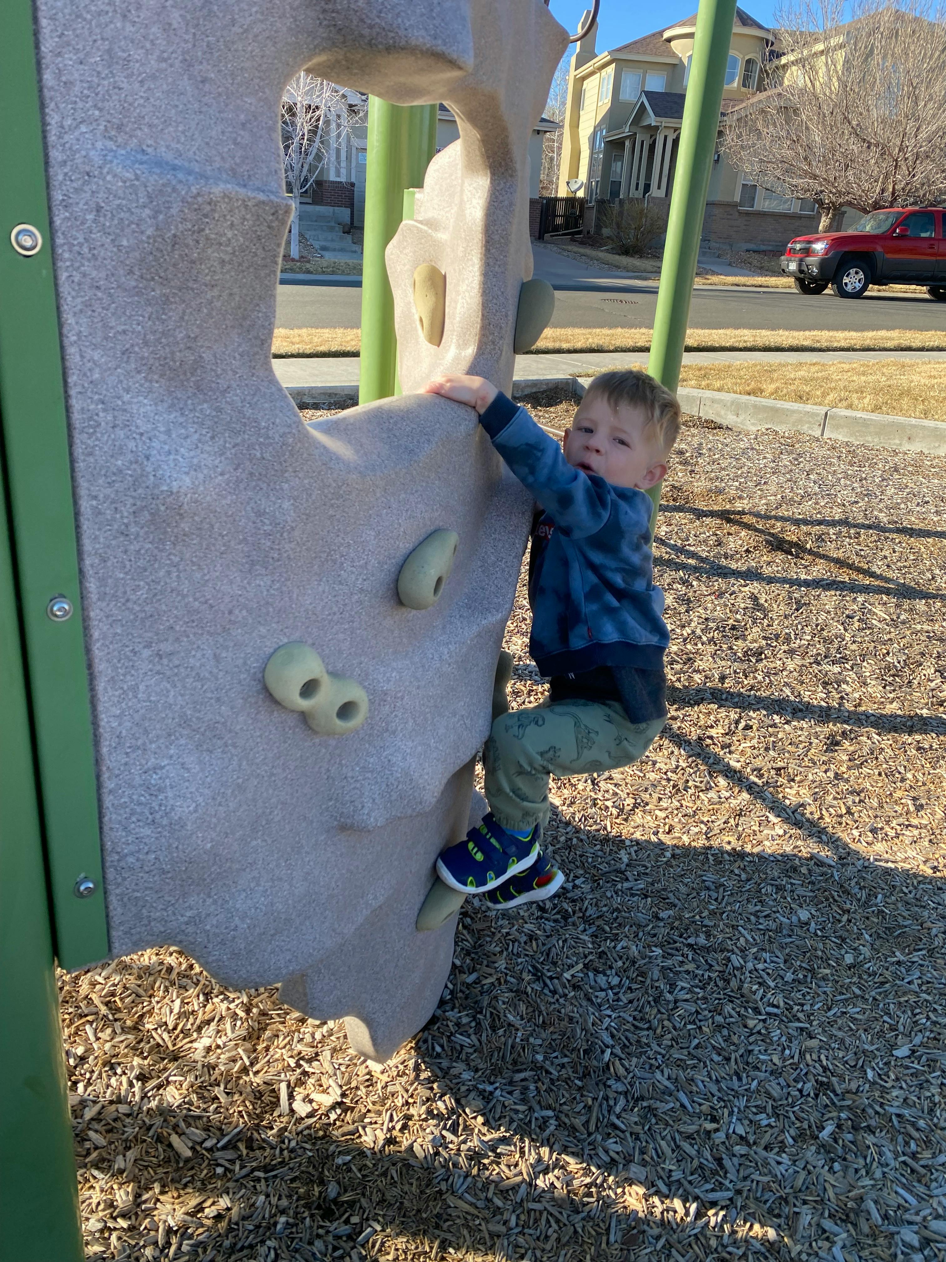 Child climbing on a playground rock wall
